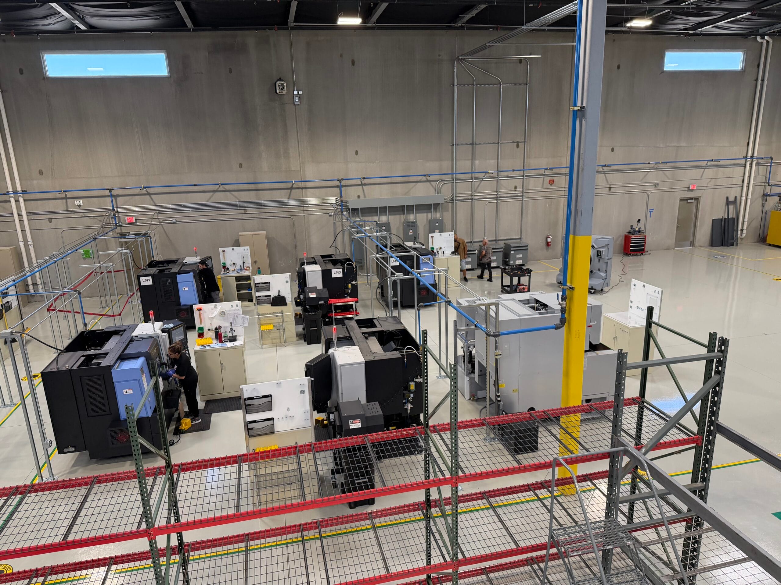 Dale Jobsite Clark Electric LV LLC Clark Electric LV LLC Industrial warehouse space with CNC machines and electrical equipment behind safety fencing