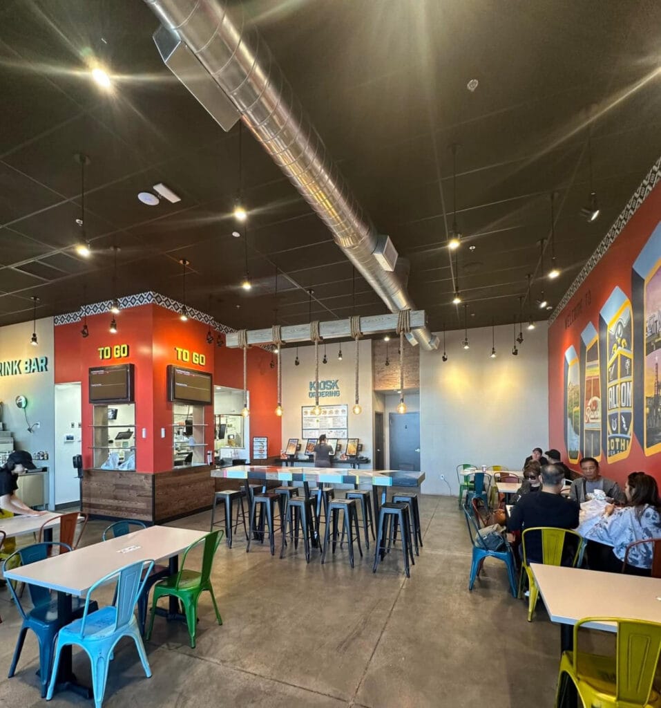 Modern restaurant interior with colorful chairs bar seating and professional LED lighting throughout the contemporary space
