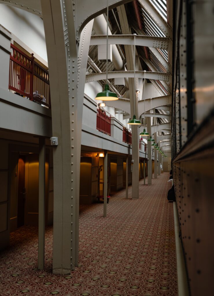 Industrial corridor with exposed steel beams pendant lighting and commercial grade infrastructure showcasing modern electrical systems