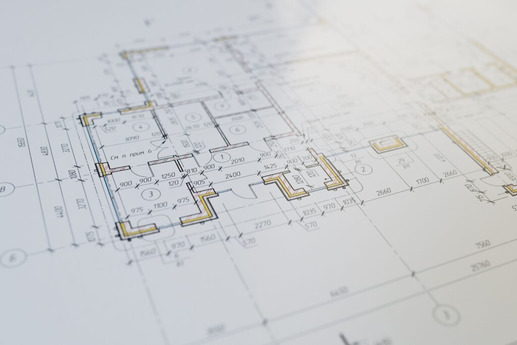 Architectural blueprints showing a detailed floor plan with rooms walls and measurements