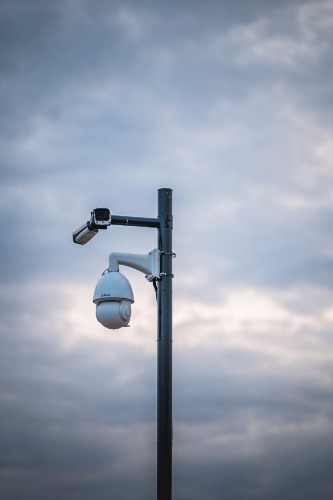 CCTV camera on a metal pole against a cloudy sky dome shaped security camera monitoring area